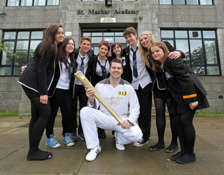 Trainee lawyer Ryan Whelan returns to show the Olympic torch to pupils at his old school, Machar Academy.
