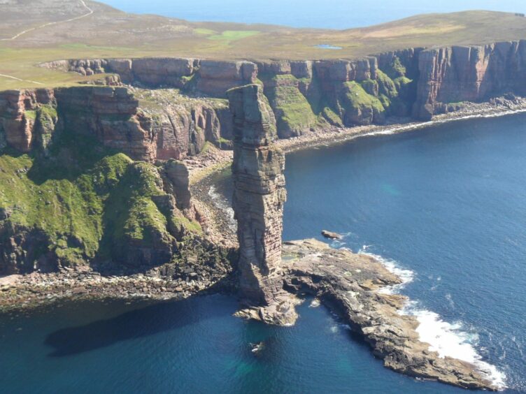 A boy has climbed the Old Man of Hoy on the Orkney Islands.