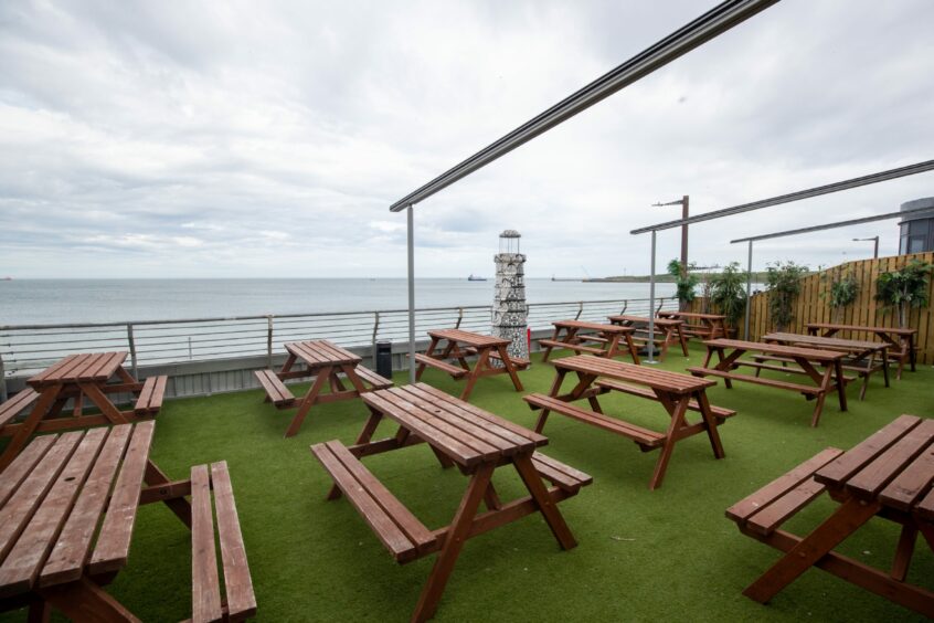 The bar's outdoor seating area with a view of the sea