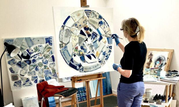 An artist in her studio working on a project