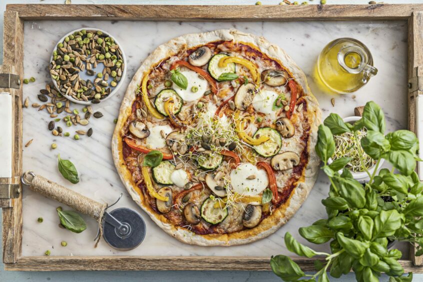 Vegetable pizza with toppers and sprouts.