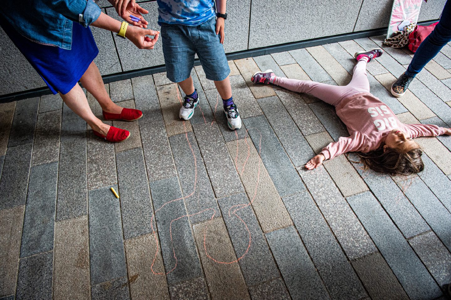 Children creating art with chalk on the ground outside Marischal Square during Nuart's Chalk Don't Chalk event