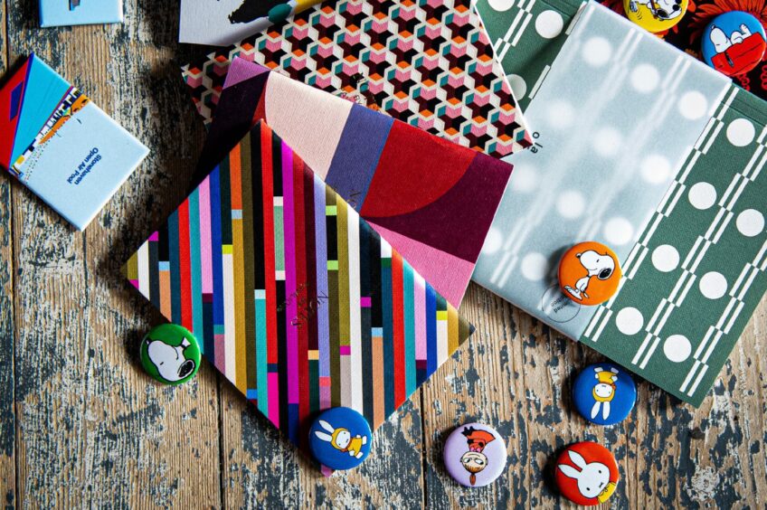 Colourful notebooks and pin badges.