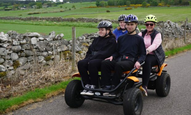 Four young people in a berg buggy at Highland Cycle Ability Centre