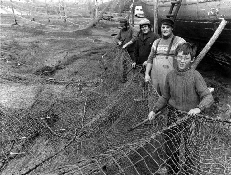 Salmon fishermen cleaning their nets at Port Erroll Harbour in 1982
