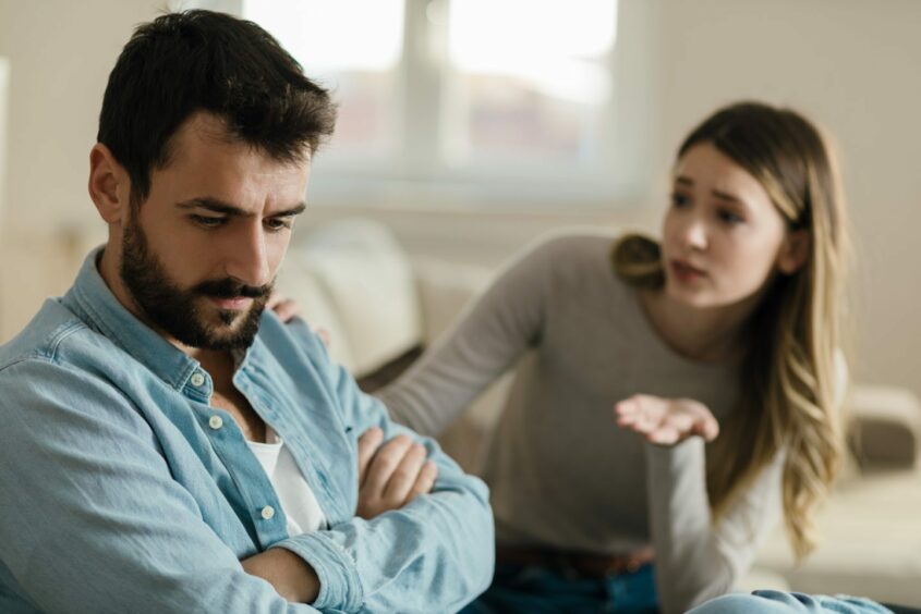 Daydreaming man with ADHD not hearing woman who is trying to speak to him