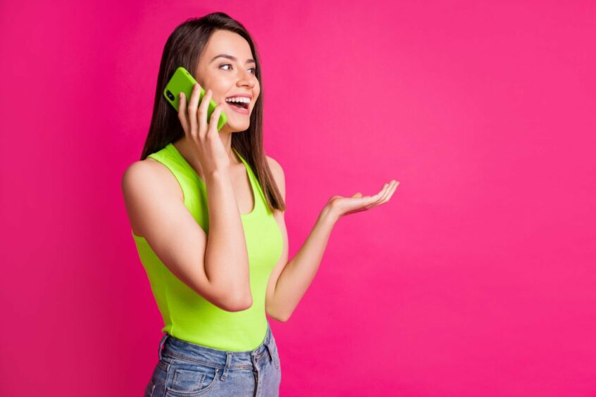 Hyperactive woman laughing and talking on her green iphone