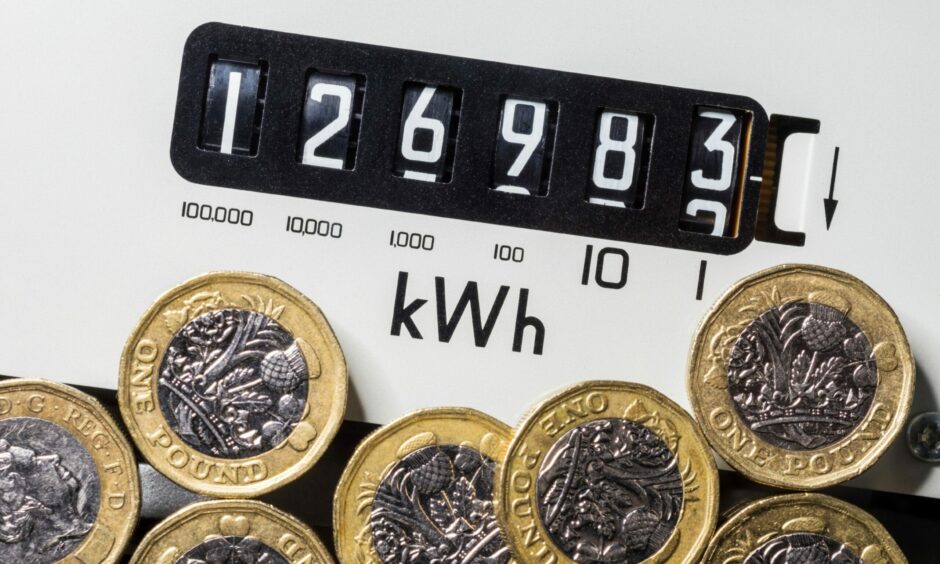 Energy meter with pound coins in foreground.