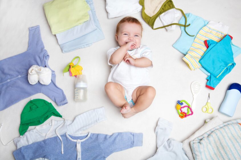 A baby surrounded by pregnancy items 