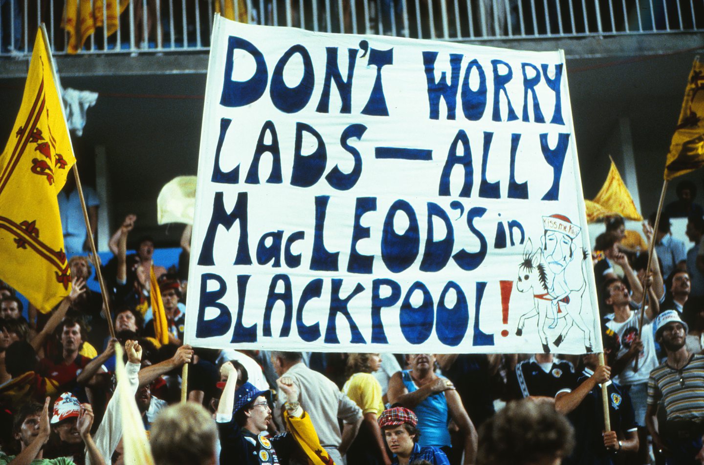 The Tartan Army holding a sign reading "Don't worry lads - Ally Macleod's in Blackpool" at the 1982 World Cup in Spain