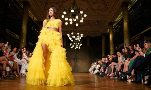 A model in yellow on the runway at the Aadnevik SS22 show. Picture: Jonathan Brady/PA Photos.