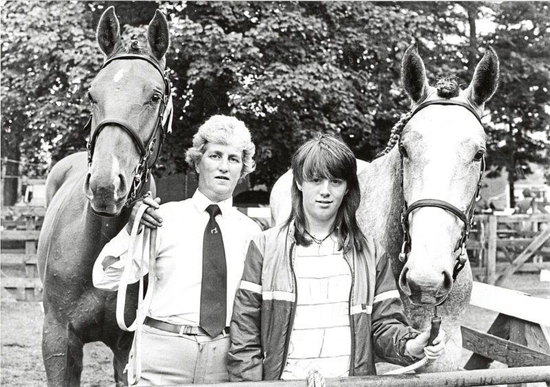 A woman and her daughter with their horses at the show