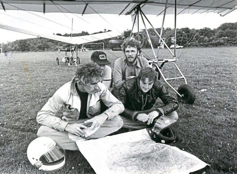 A group of men planning their hang gliding journey