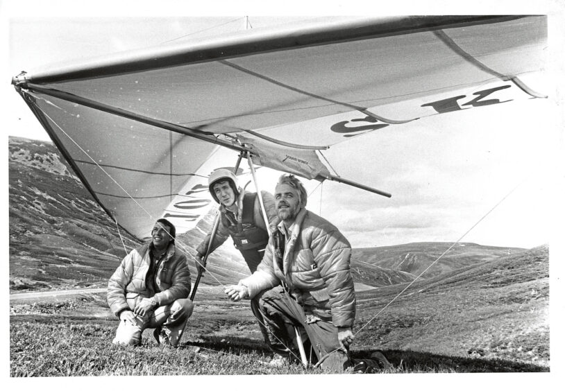 Three men hang gliding
