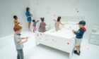 Children apply the first stickers to Yayoi Kusama's interactive work The obliteration room at the Tate Modern in London. Aaron Chown/PA Wire