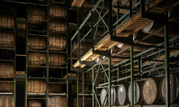 Whisky casks stacked up in warehouse.