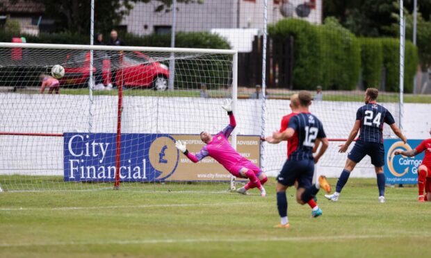 Brora's Joe Malin is helpless to stop Kazeem Olaigbe from opening the scoring for County.