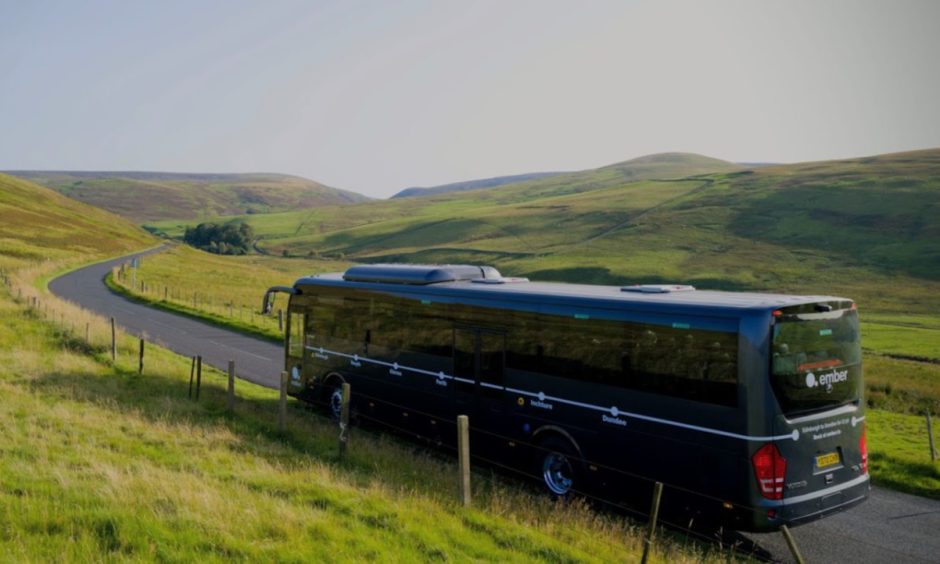 Ember bus on empty Scottish road.