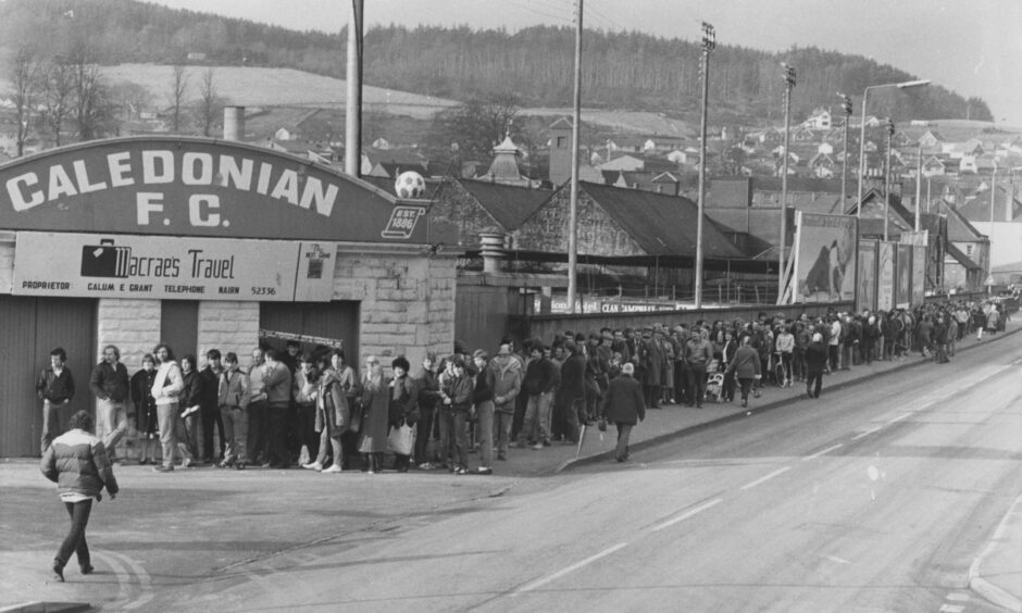 People queueing outside the Telford Street Park, Inverness with a sign above reading "Caledonian FC"
