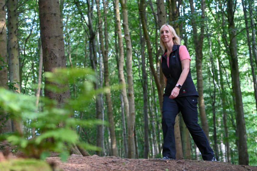 Gillian Fowler, of Usana Mindset, walking through a forest 