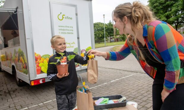 Rebecca Dunn, development worker for Cfine, handing out mini kits for little growers. Picture by Kath Flannery.