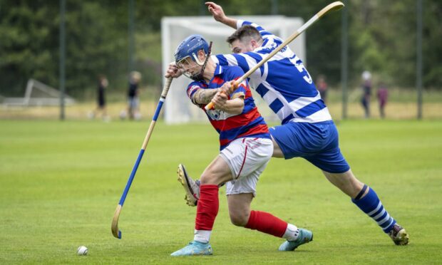 Newtonmore's Steven Macdonald goes to block the swing from James Falconer (Kingussie). Image: Neil Paterson.