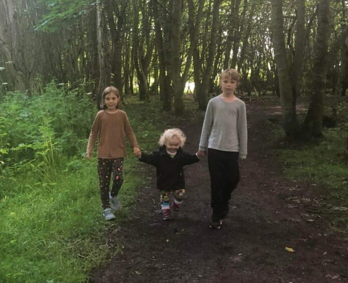 The three kids walking in the woods