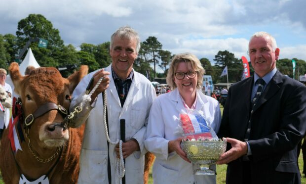 TOP PRIZE: Beef interbreed judge Andrew Reid presents the cup for the top show award to the Robertson family from Fodderletter, Tomintoul.