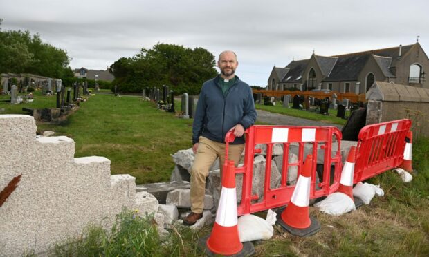 Reverend Paul McKeown beside the damaged wall. Picture by Paul Glendell