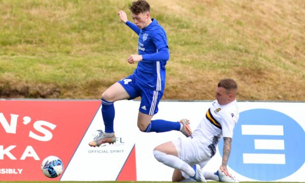 Peterhead's Robbie McGale hurdles a tackle from Dumbarton's Gregg Wylde.