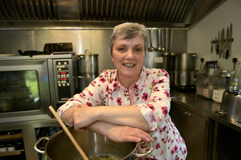 Katrina leaning on a big pot in her kitchen