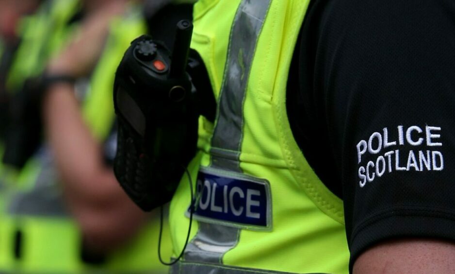 Police in a uniform with a radio, not showing her/his face.