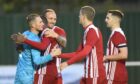Ewen Macdonald is congratulated by his Formartine team-mates after his spot kick saves