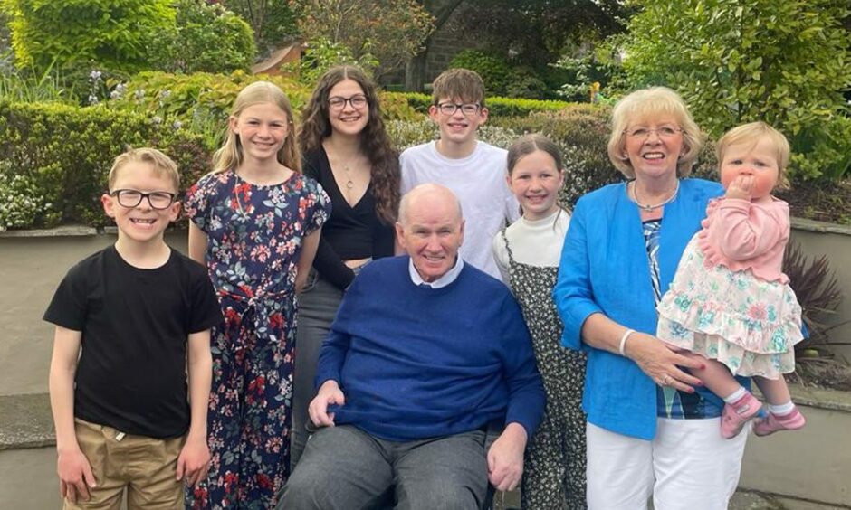 Alfie Cordiner is shown centre in a photo surrounded by his grandchildren and accompanied by his wife.