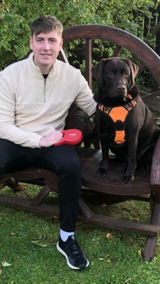 Cameron Boyle pictured with his chocolate labrador Phoebe.