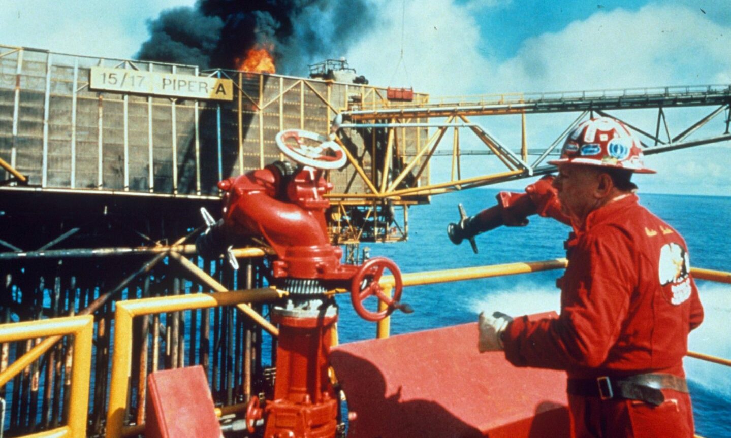 Red Adair working to tackle the Piper Alpha oil rig blaze in his trademark red overalls.