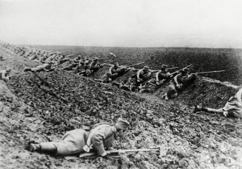 Soldiers lined up to shoot during World War One.