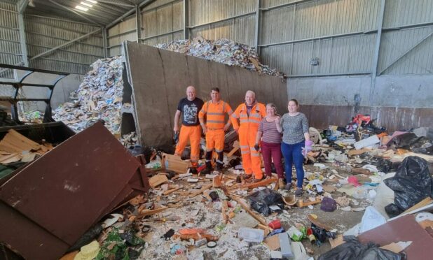 Recycling centre staff with Brian Gordon's wife and daughter after finding the ashes.