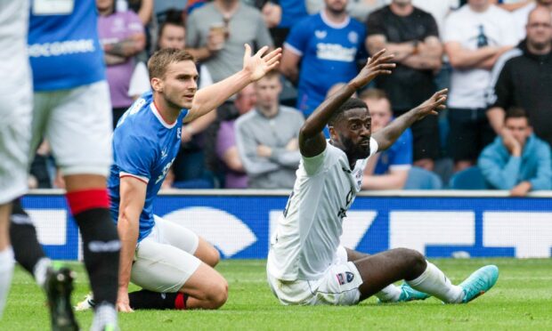 Jordy Hiwula on the ground after being taken down by Rangers' James Sands.