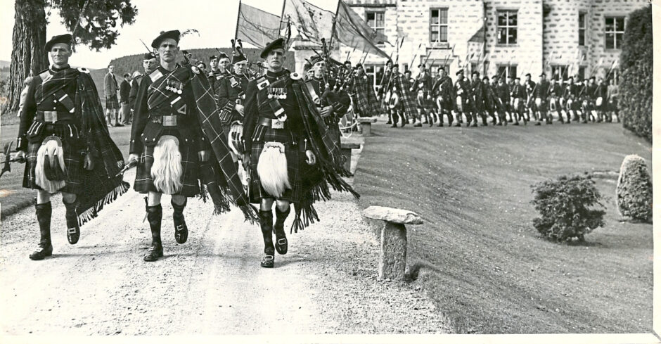 Lonach Highlanders marching down a road