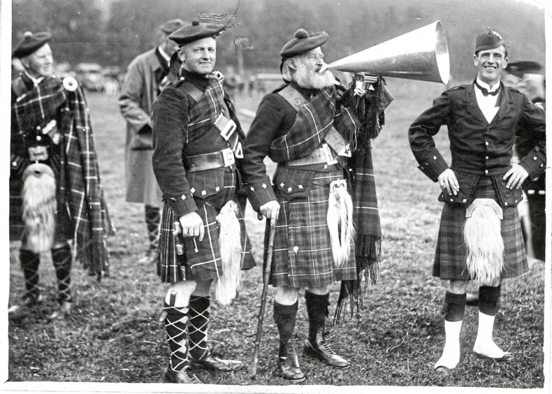 The oldest clansman in the group speaks to the Highlanders through a large megaphone at the Lonach Gathering