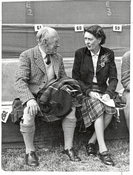 A woman and man sitting and talking at the Lonach Gathering