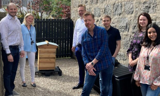 CMS Aberdeen managing director Norman Wisely, front centre, and colleagues with their new beehive.