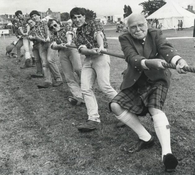 Lord Lieutenant of Aberdeenshire, Sir Maitland Mackie shows off the style which earned him a place on the rope in the tug-o-war battles between the Mackies and the Millers just after World War II in his home territory. The Kinneff team are pictured behind giving him a bit of support.
