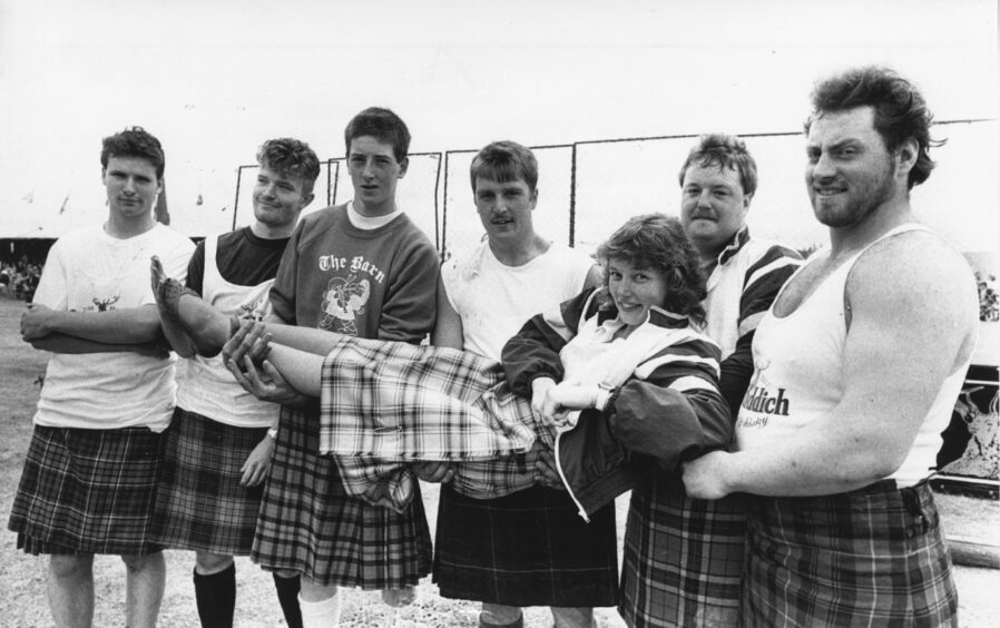 1989- The Glenfiddich Heavyweight Novice competitors lift lightweight Mandy Nicol, from Aboyne. The competitors are (from left): Craig and Mark Anderson from Aberdeen, Bruce Aitken from Auchenblae, Gordon Martin from Kennethmont, Tommy Dow from Kincardine O'Neil, and Ron Young from Insch