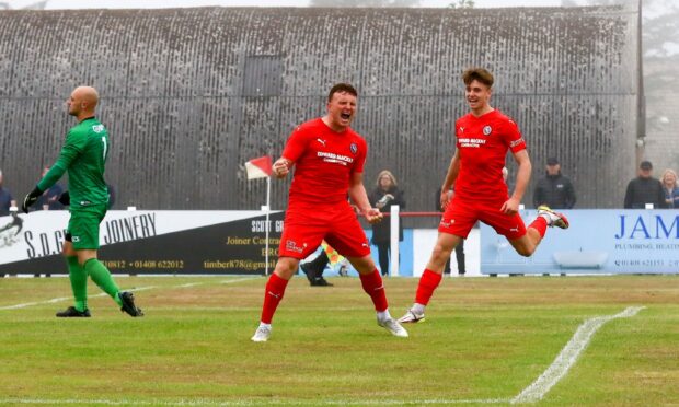 Brora's Tony Dingwall, centre, celebrates with Gregor MacDonald, right, after giving the Cattachs the lead against Banks o' Dee