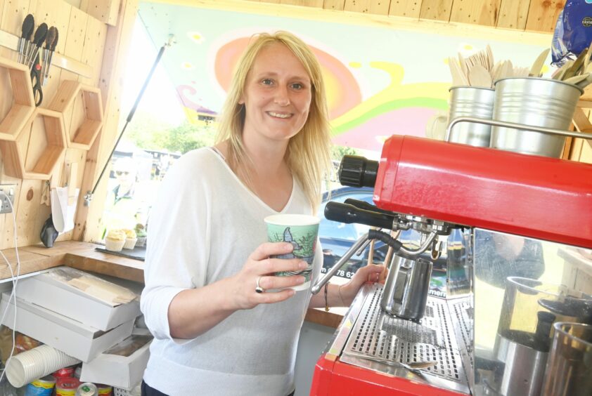 Anna Cartliege standing in front of a coffee machine with a cup in her hand