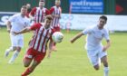 Formartine United's Scott Lisle, left, and Tom Kelly of Brora Rangers chase the ball