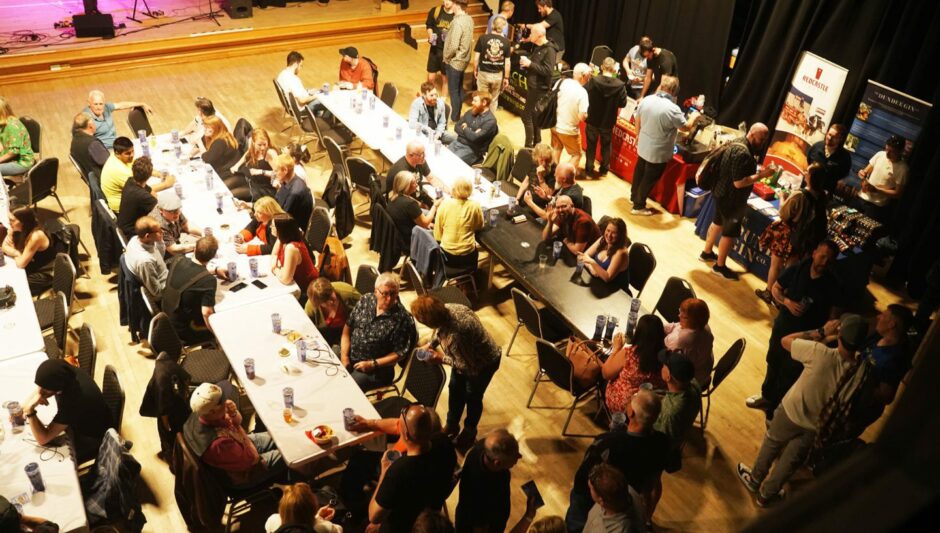 The Dundee brew fest, people sitting enjoying beers inside the venue. 