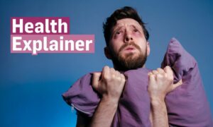 sleep deprived man gripping pillow in despair next to the 'Health Explainer' logo